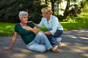 Passerby helping senior woman in park